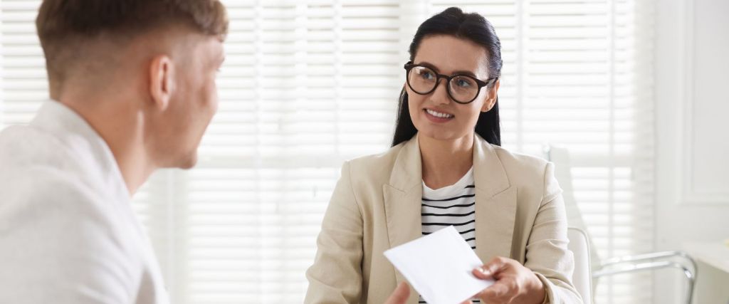 Woman passing paper over to man